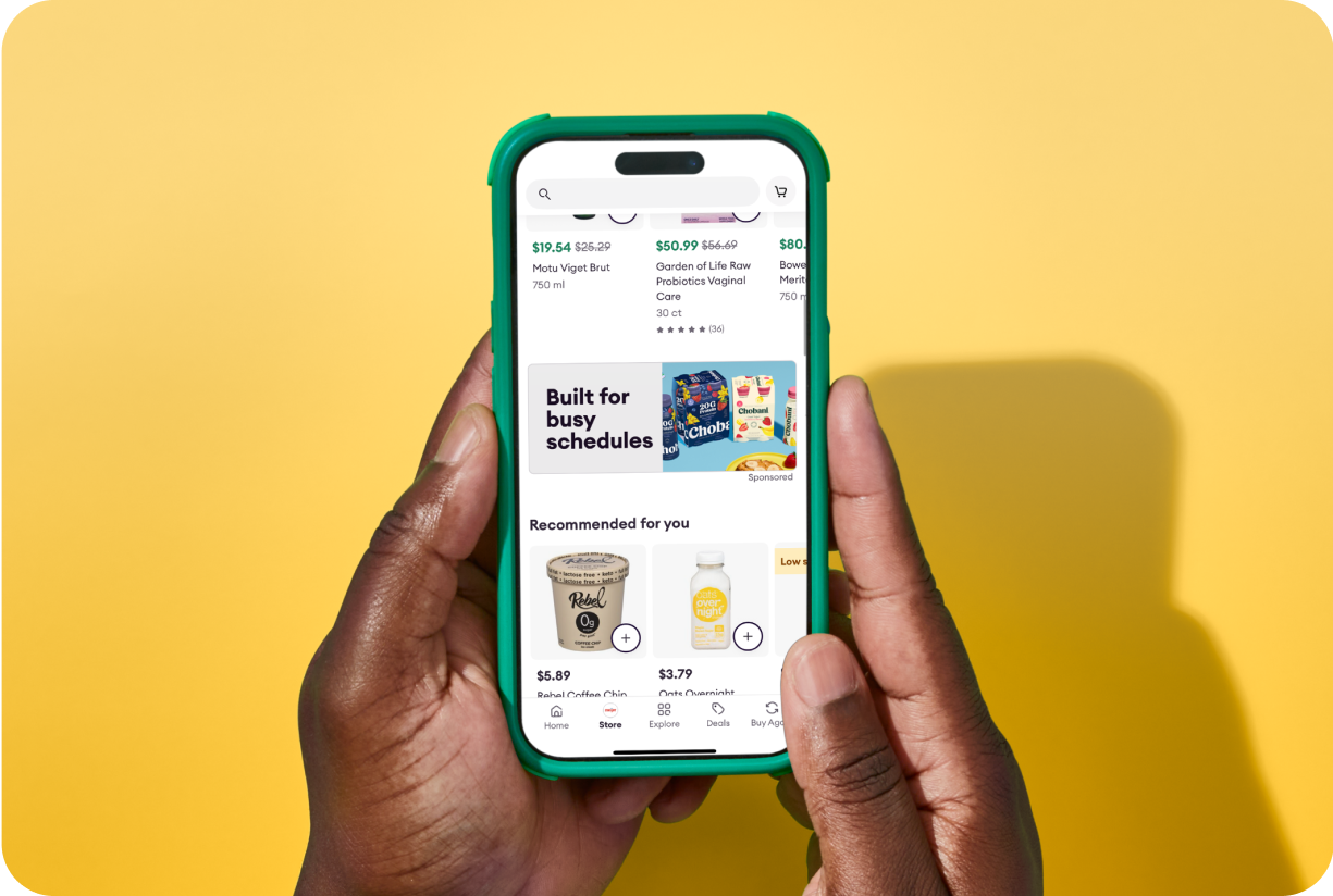 Two hands holding a mobile device looking at the Shipt user interface