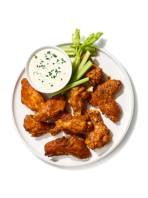 Hot wings with small bowl of dipping sauce and celery 