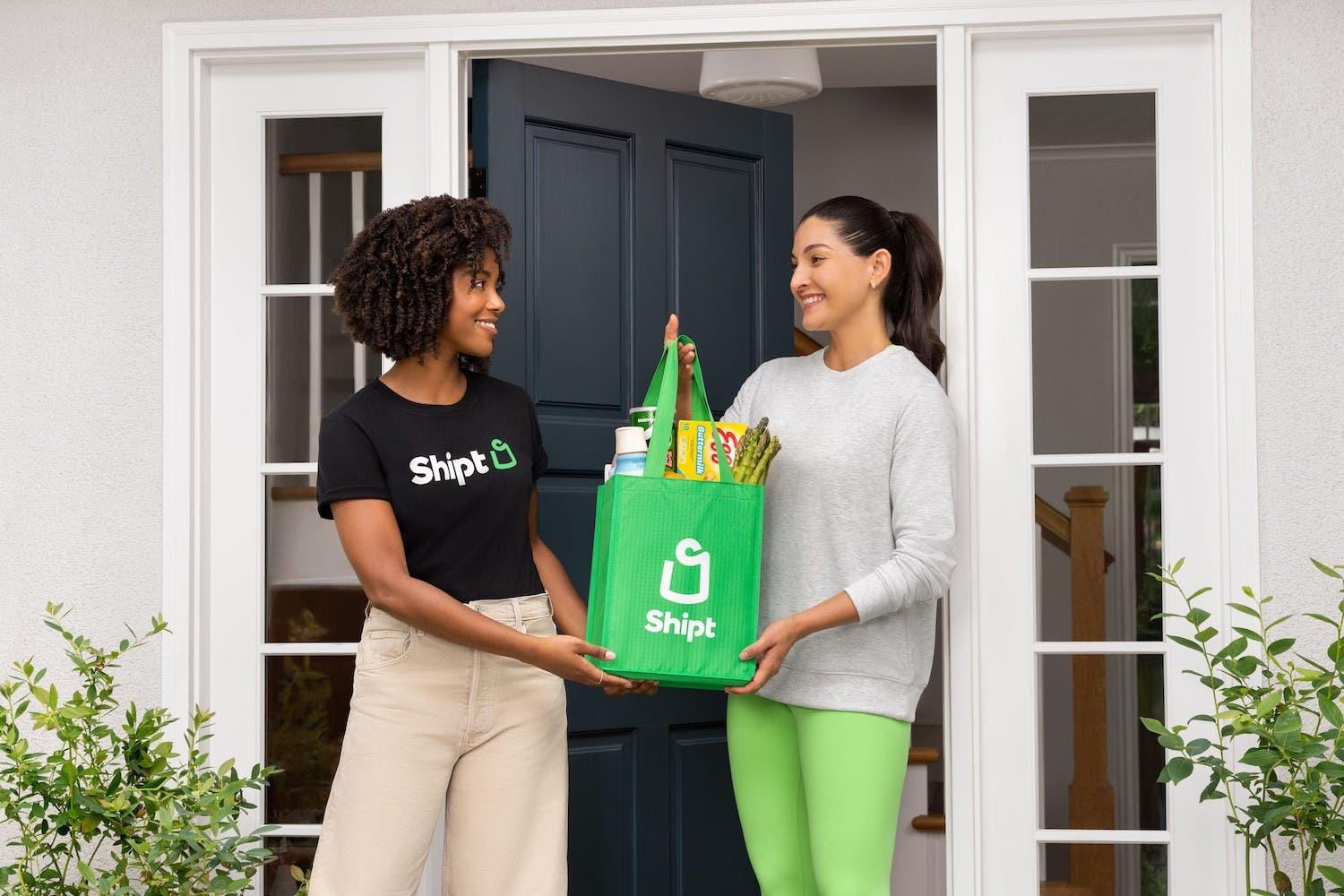 Issa Rae holding a green Shipt bag grocery delivery in her dressing room