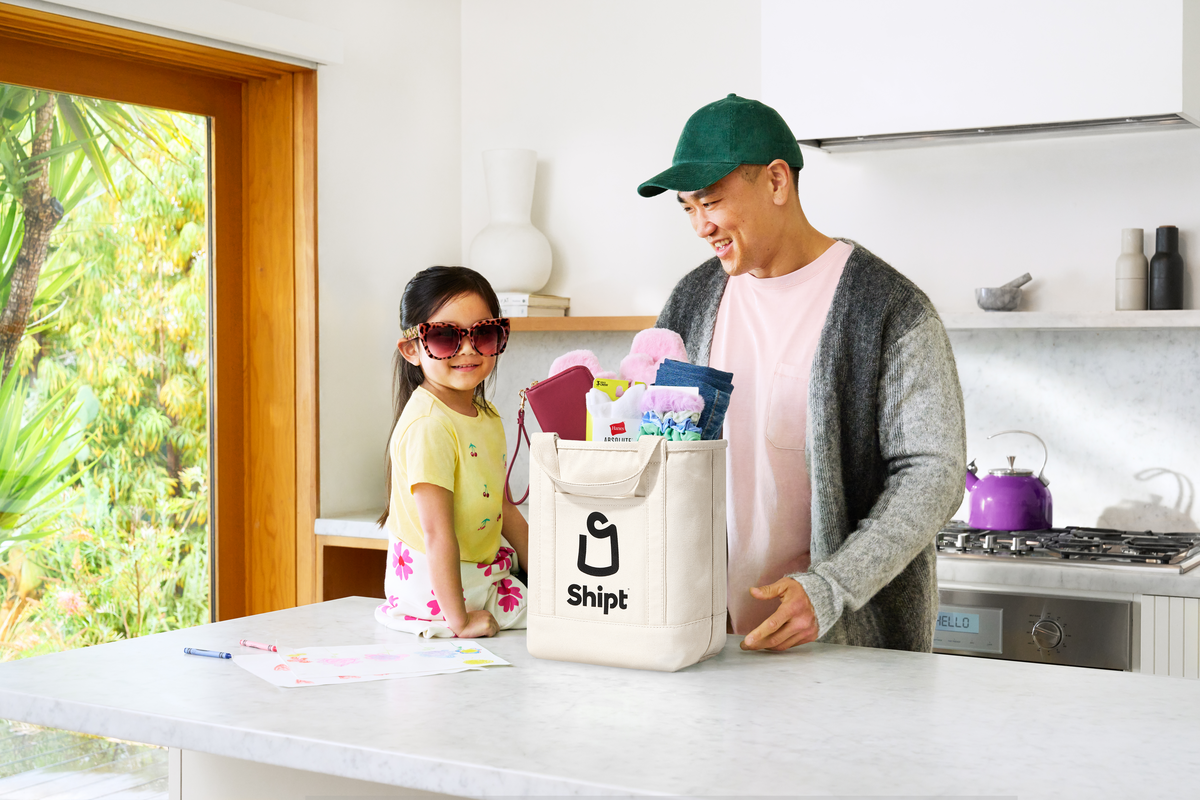 Man and daughter in kitchen unpacking delivered groceries