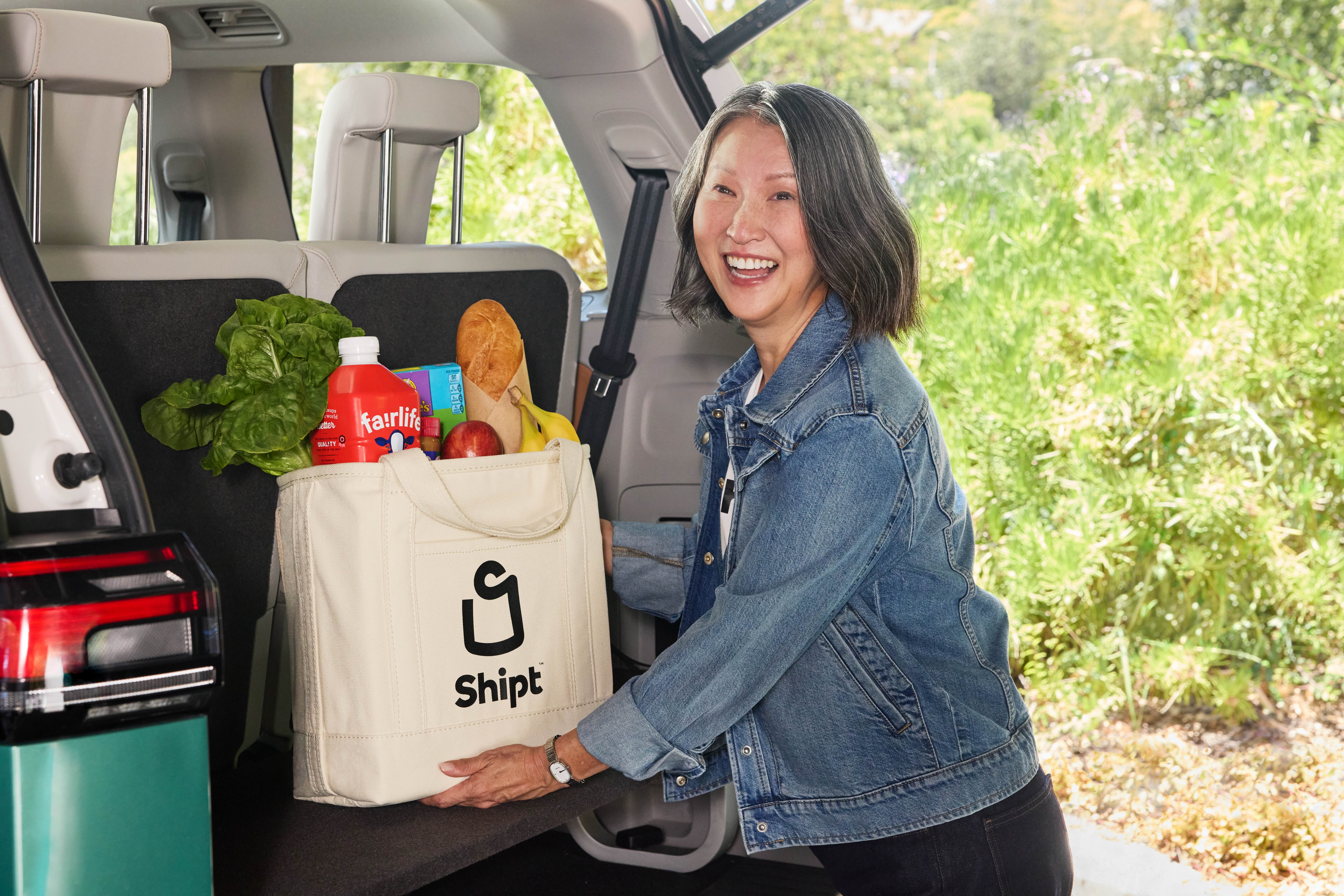 Shopper loading groceries into trunk