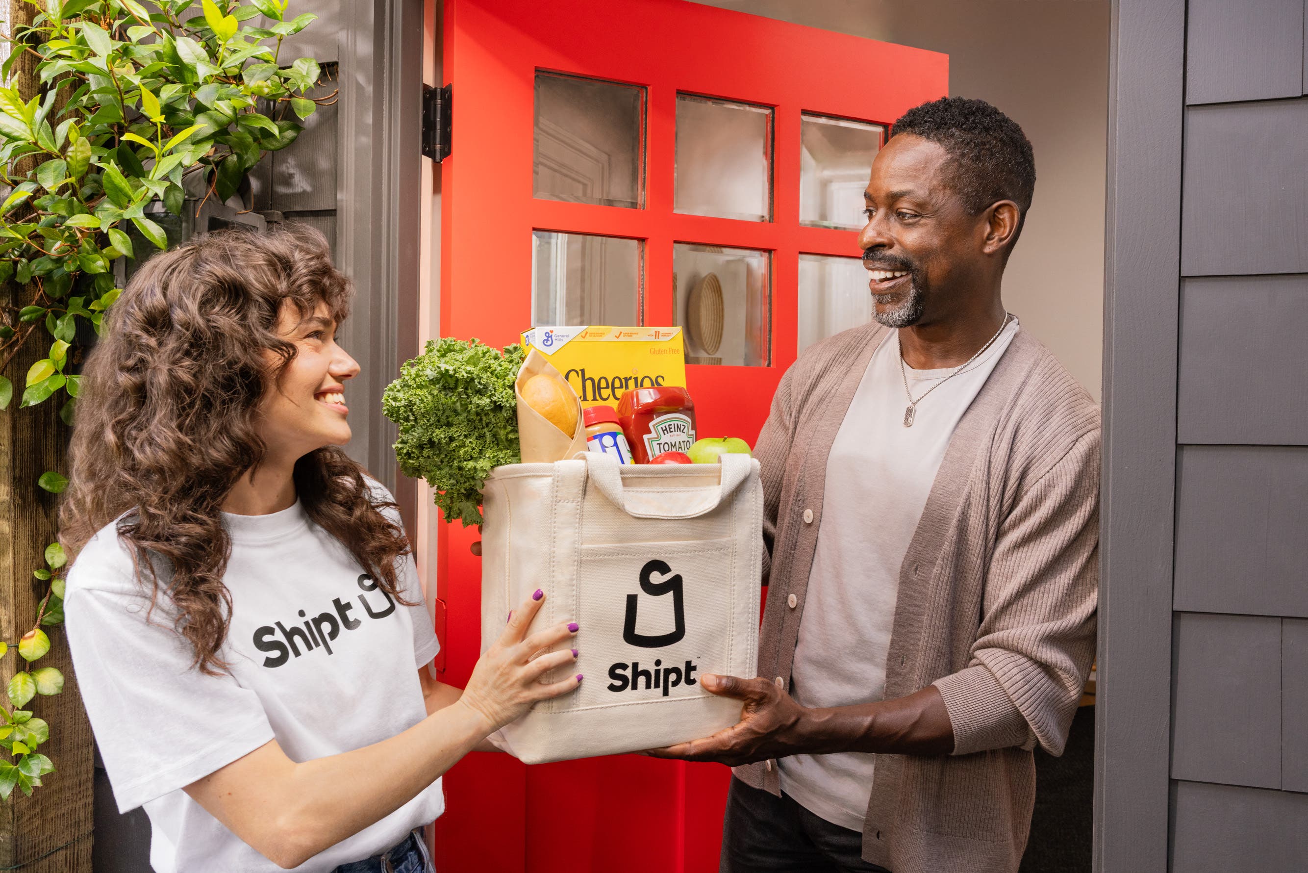 Shopper handing Shipt delivery to Sterling K. Brown at his front door.