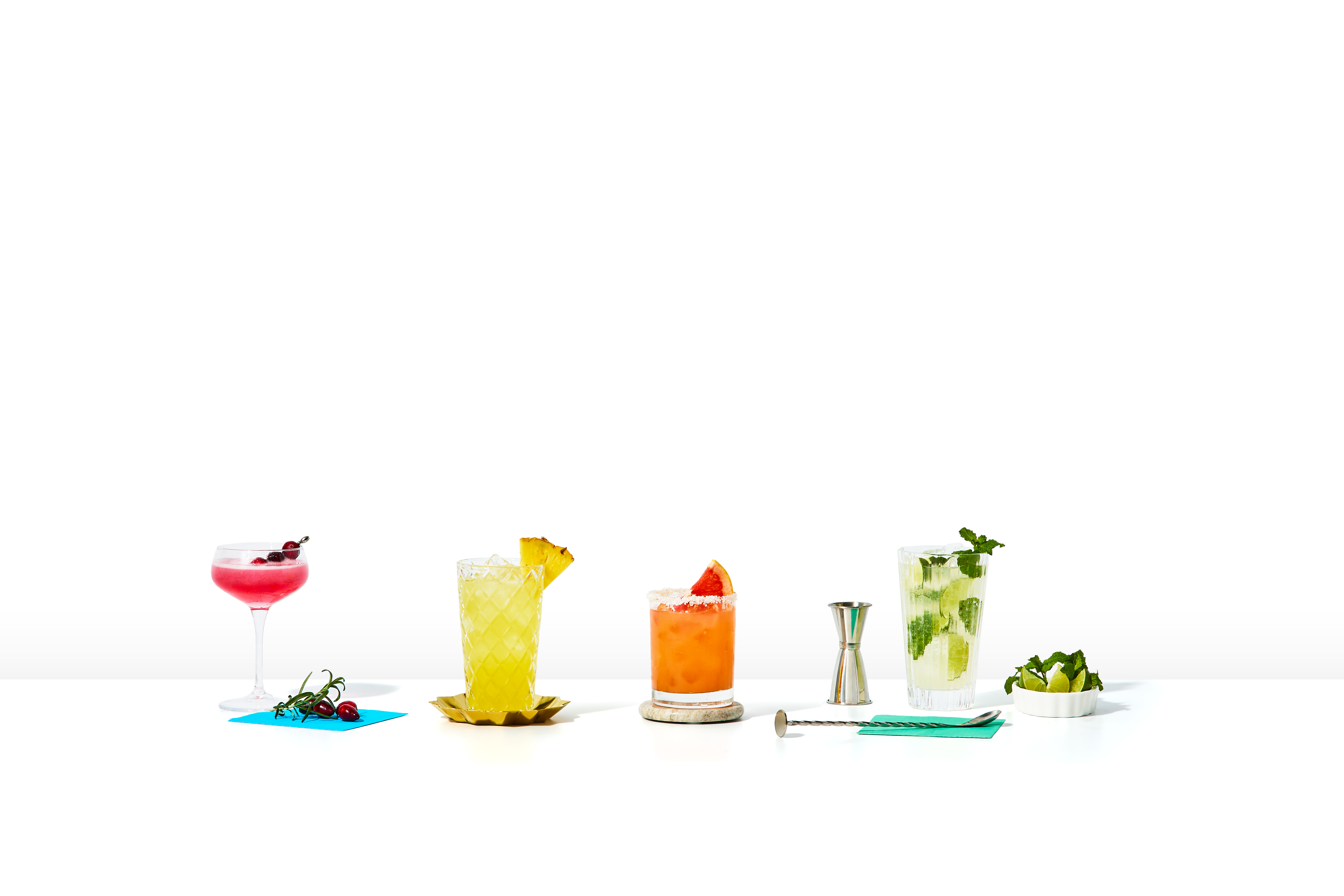 Oatmeal-colored shopping bag with Shipt logo filled with alcohol, mixers, and barware.