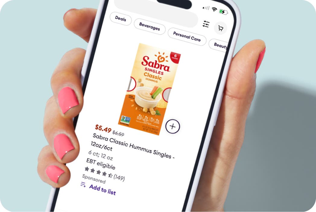 Hand holding a phone showing Sabra Hummus product.