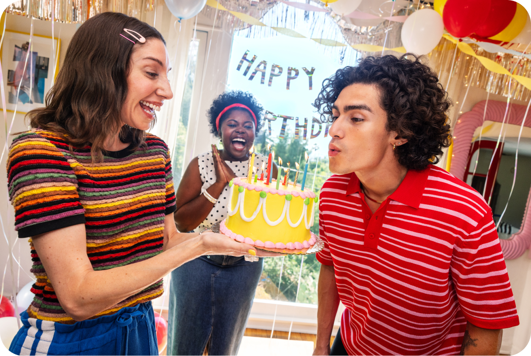 A birthday party scene with someone blowing out candles on a cake