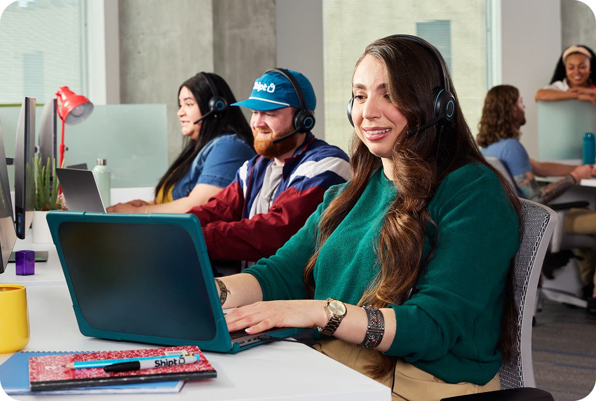 Image of female customer service rep on a call and her laptop assisting a customer