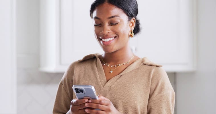 Woman smiling and looking at phone screen