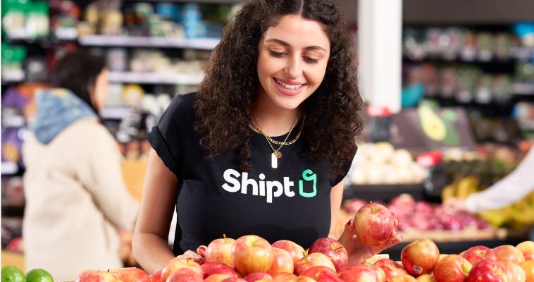 Woman in Shipt t-shirt selecting fresh produce