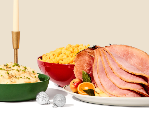 A sliced spiral ham and side dishes