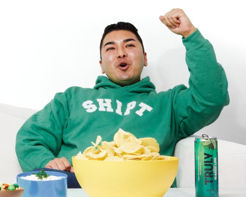Image of man in sweatshirt cheering team on