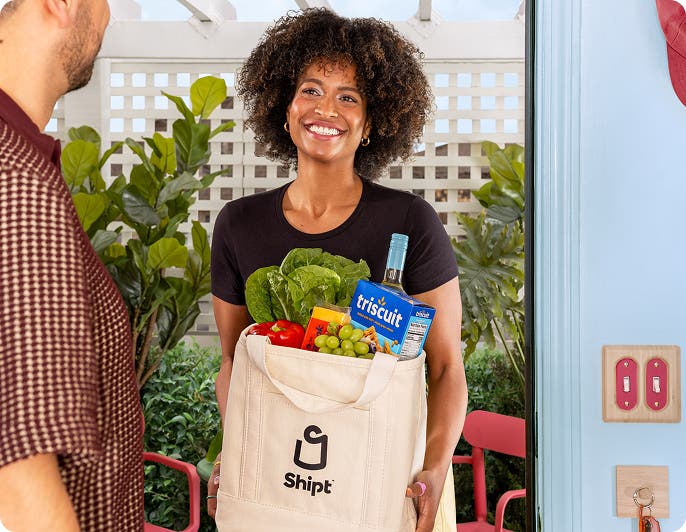 Shopper with Shipt delivers groceries to a customer