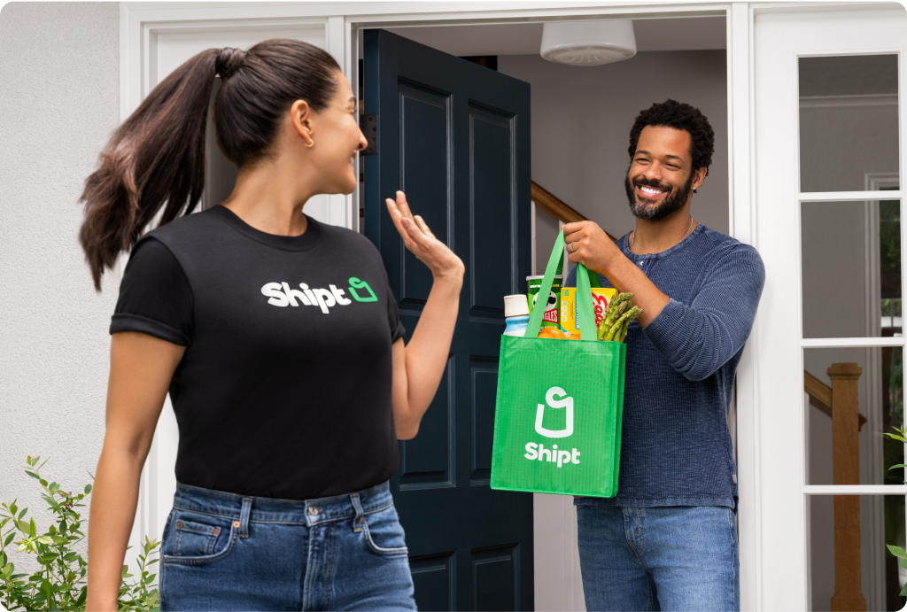 Happy woman delivers a bag of Shipt groceries to a member