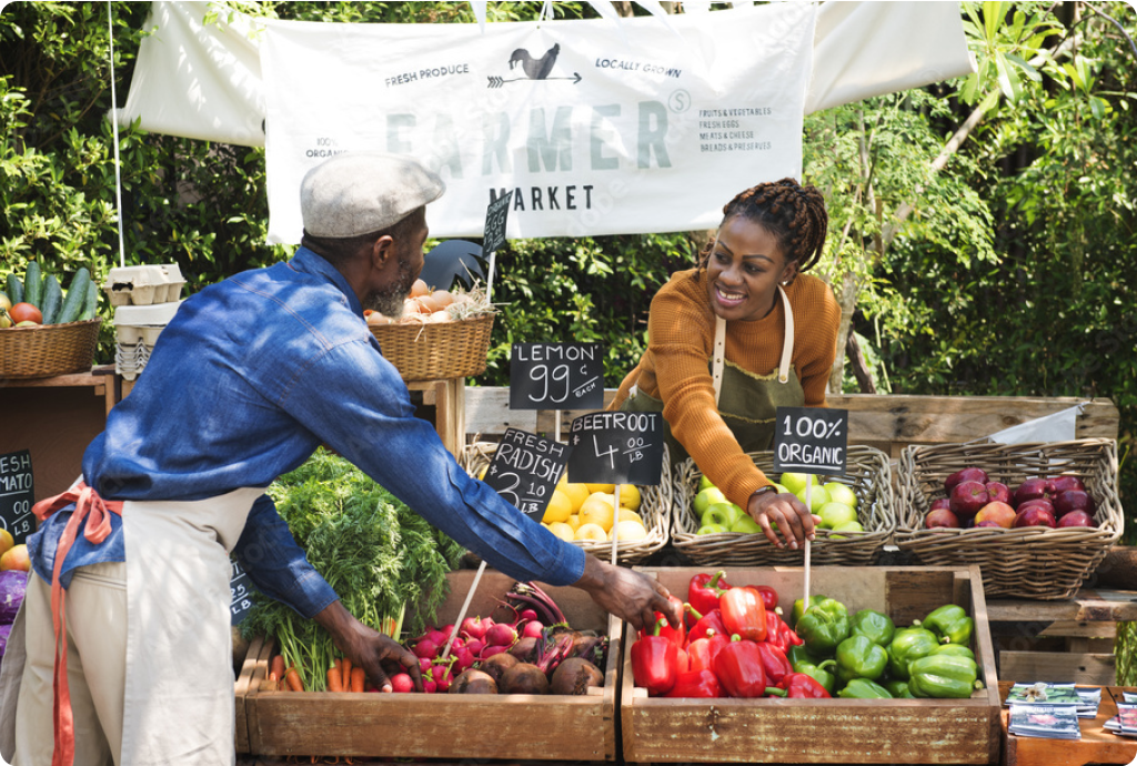 two people selecting produce at an outdoor market