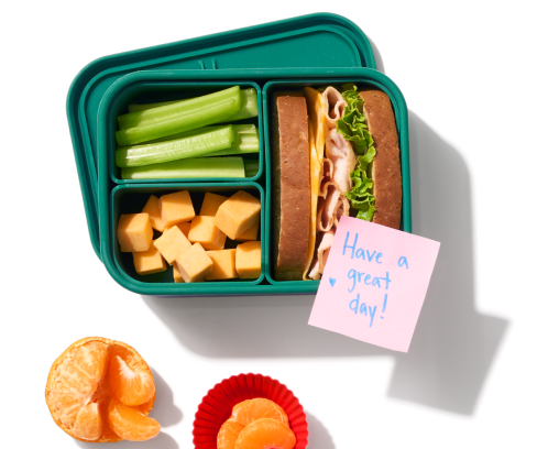 Bento box with packed lunch and fruit on a table