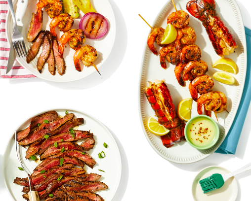 White platters of meat and seafood on a white tablecloth