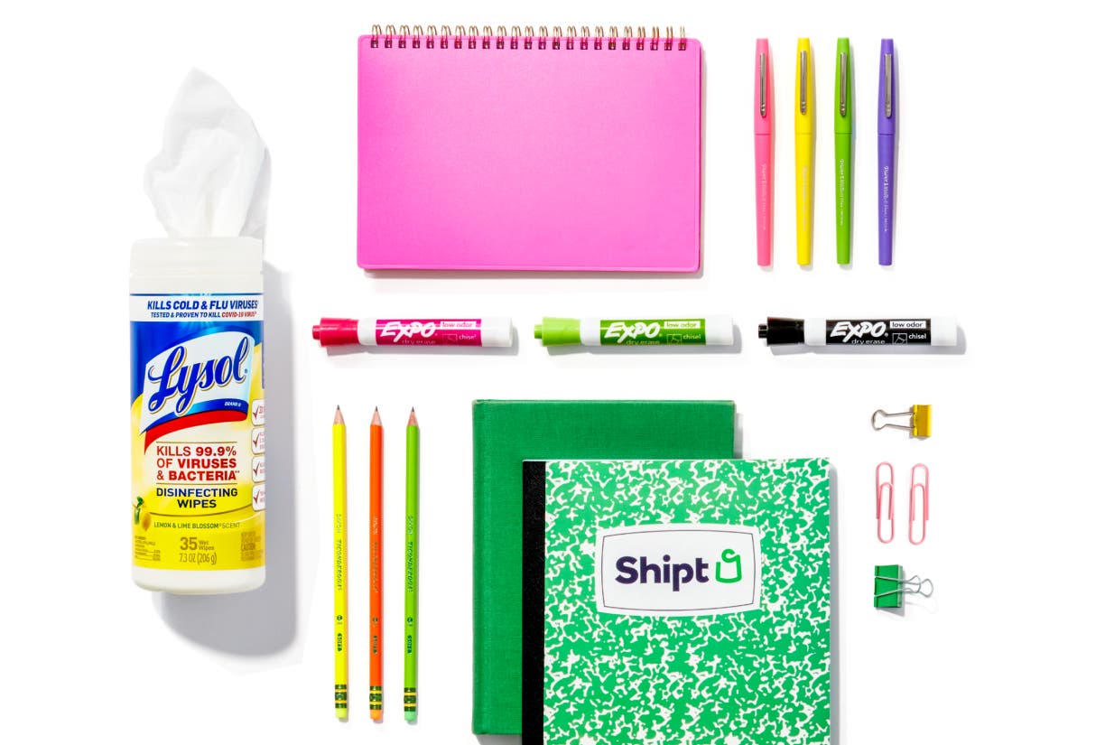 Colorful selection of notebooks, dry erase markers, pencils, and pens on a white background