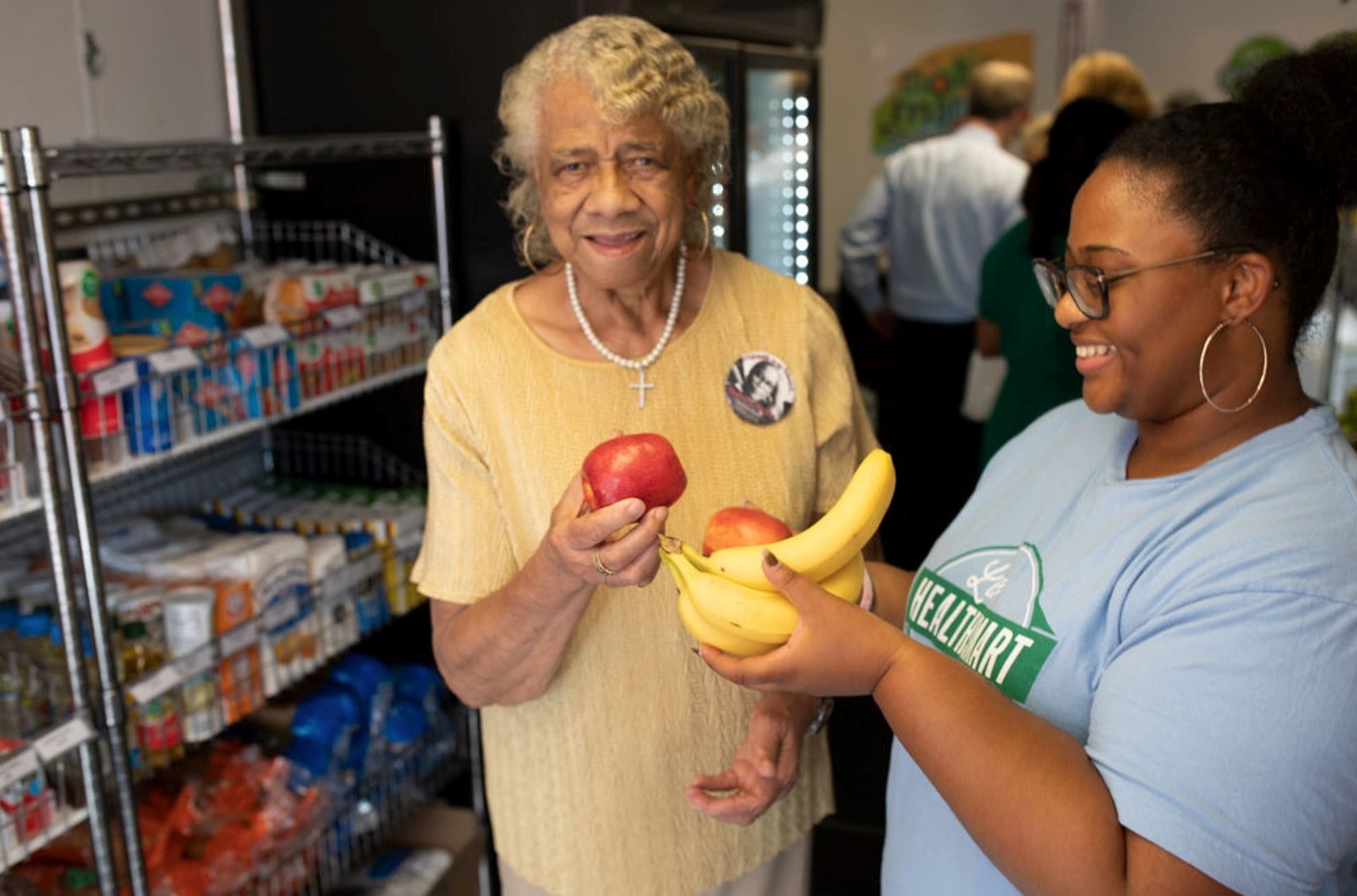 grocery market pop up serving bananas and apples to community member