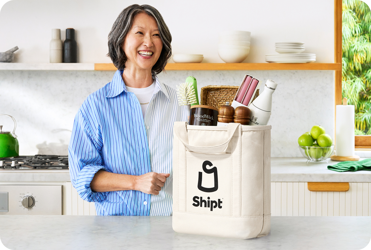 Image of woman in her kitchen with Shipt bag containing several items on her counter