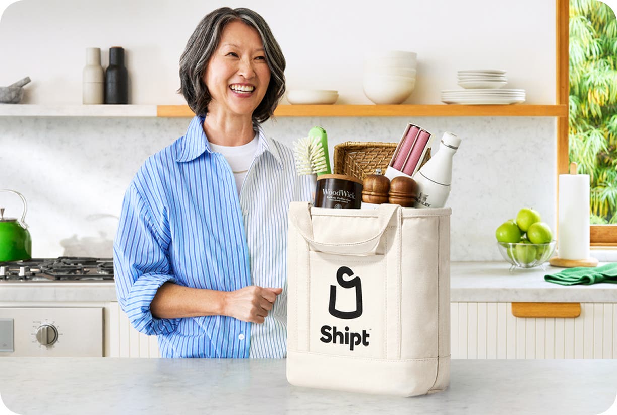 Image of woman in her kitchen with Shipt bag containing several items on her counter
