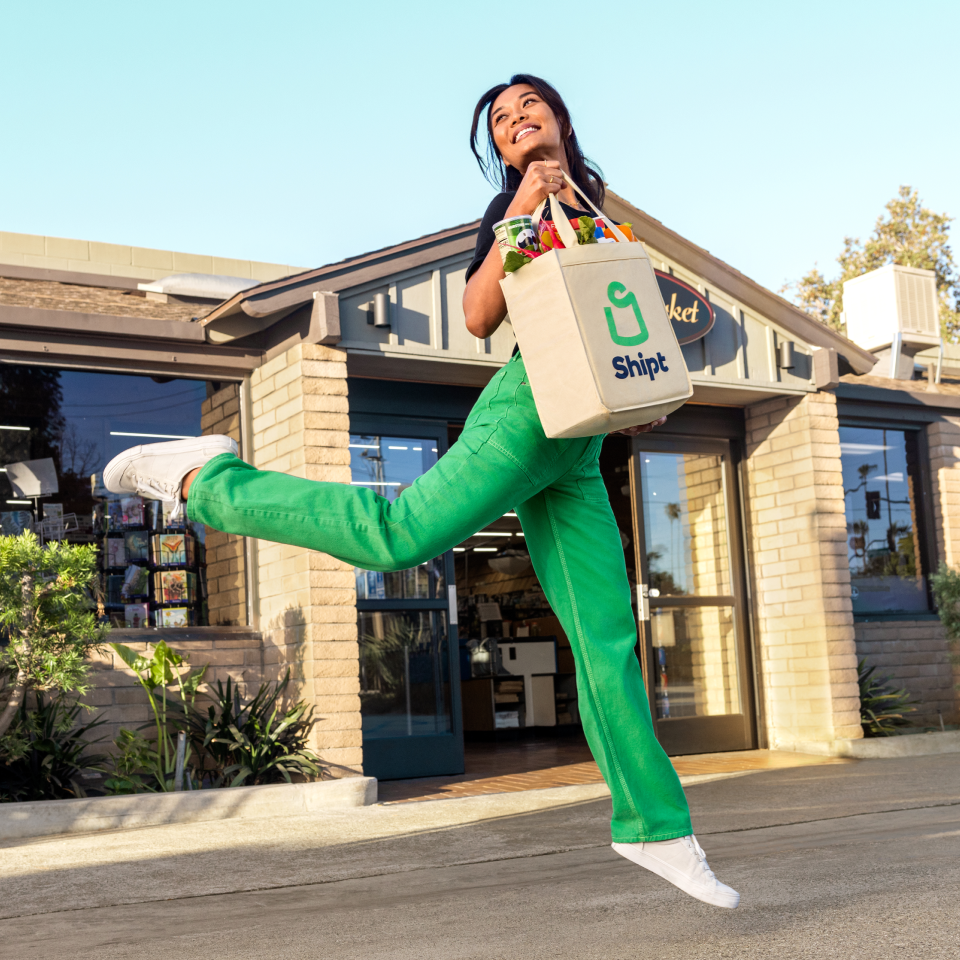 woman jumping with shipt grocery bag