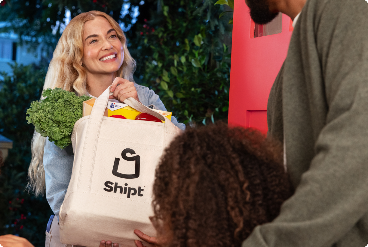 Shopper hands off Shipt totemeal bag to family at front door