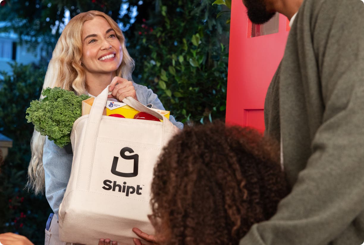 Shopper hands off Shipt totemeal bag to family at front door