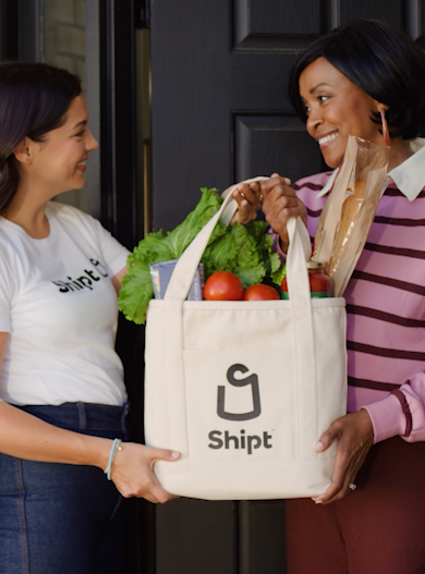 shopper handing off grocery bag to member