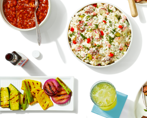 Grilled vegetables and bowls of side dishes shown from overhead