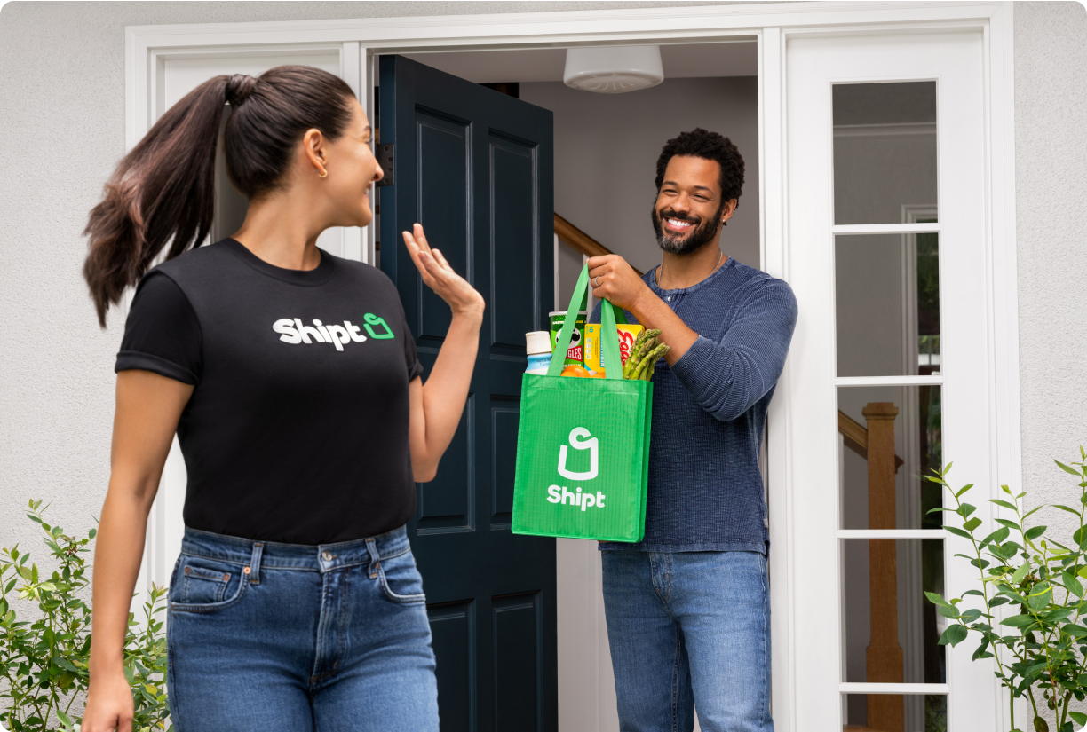 A shopper with Shipt delivers a bag of groceries to a member