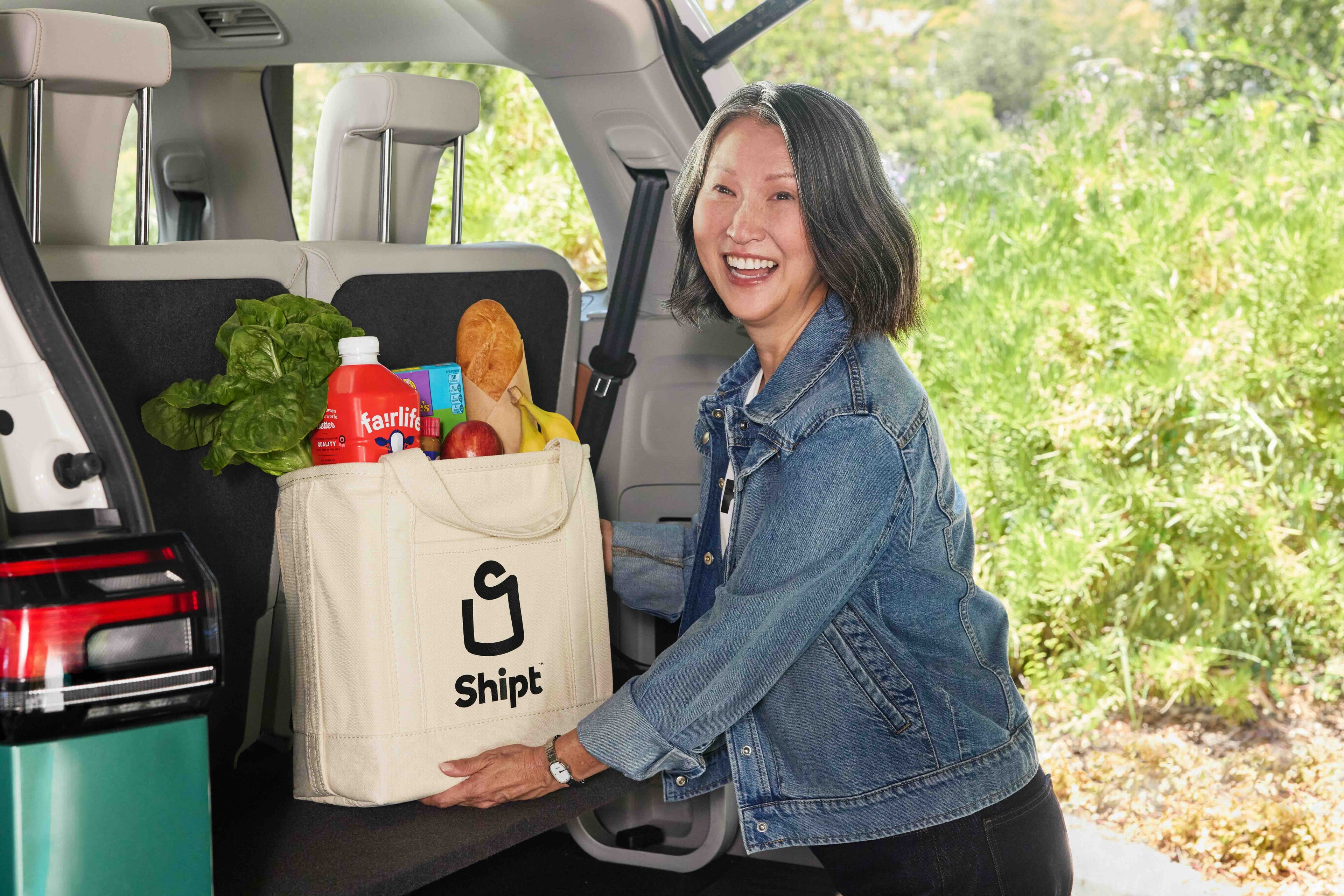 Shopper loading groceries into trunk