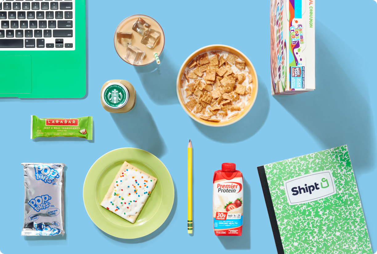 College desk full of snacks, computer, and notebook